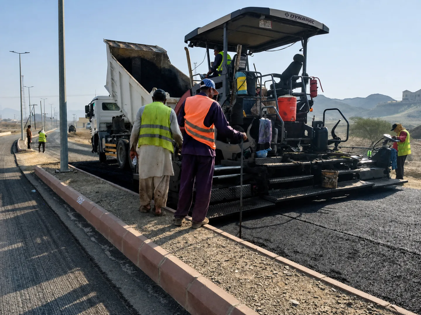 Asphalt paving crew and paver operating on a roadway project