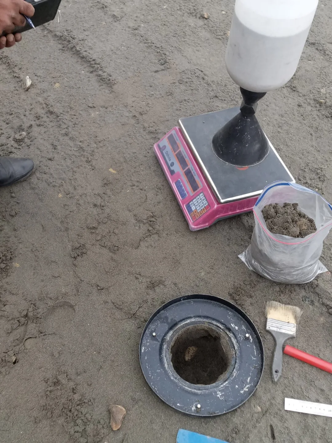 Sand-cone equipment and prepared soil sample during field-density testing