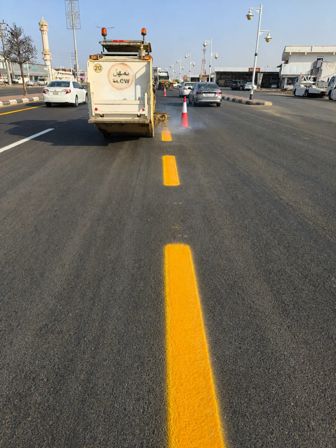 Road-marking team applying a quality-controlled pavement line